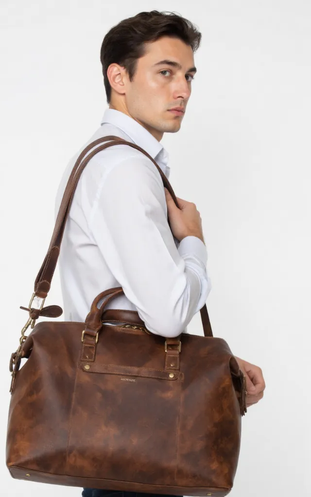 A French male model with a Holdall, wearing a shirt, against a white background, in a front   facing close   up
